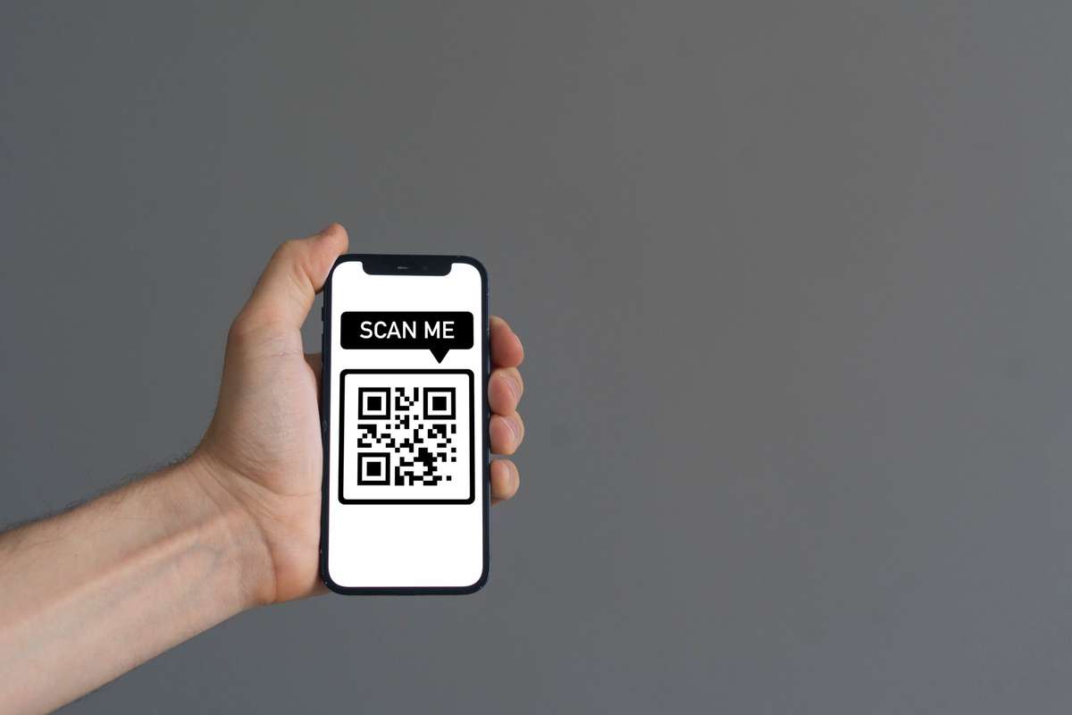 Mano sosteniendo un smartphone que escanea un código QR