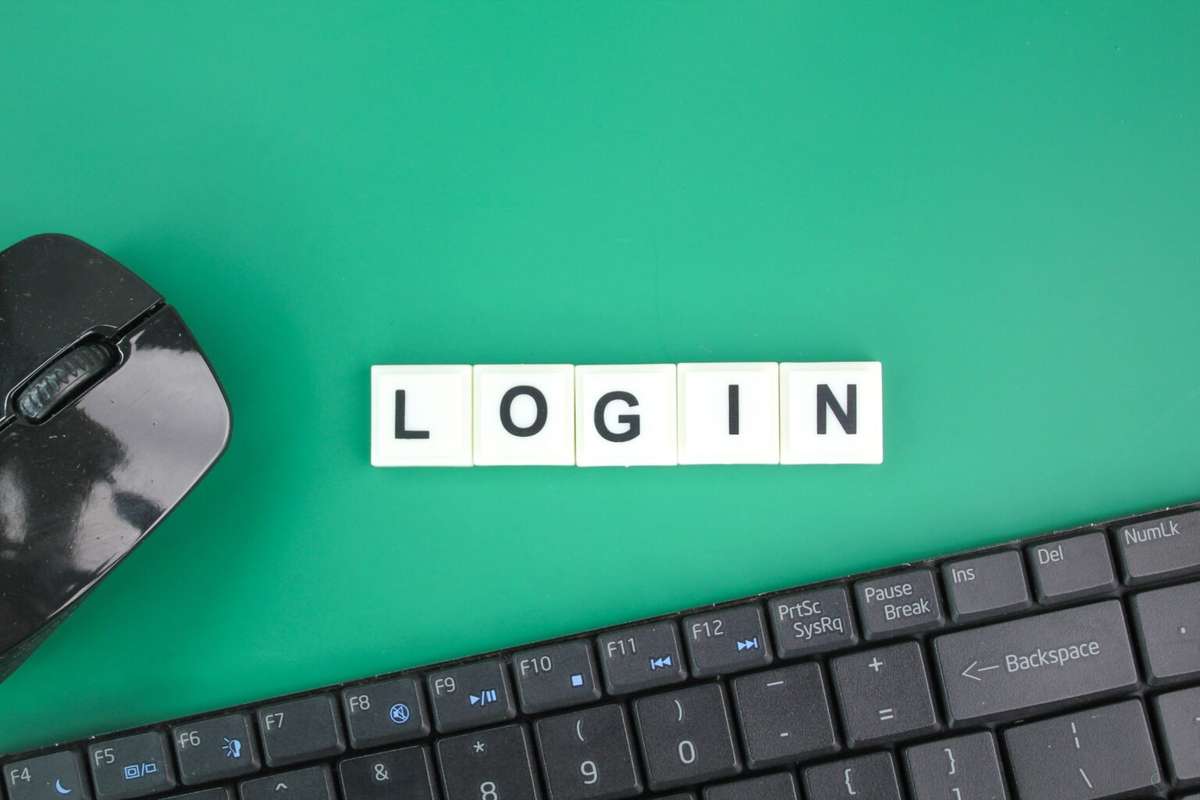 Laptop con un teclado y un ratón sobre un escritorio, junto a la palabra login
